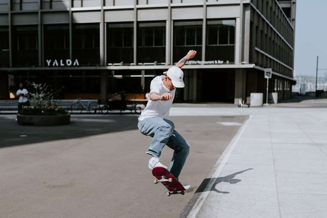 Човек в бяла риза и бели панталони играе скейтборд онлайн пъзел
