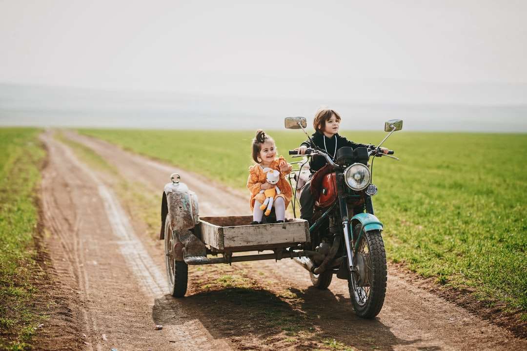 2 niños montando en la motocicleta negra durante el día rompecabezas en línea