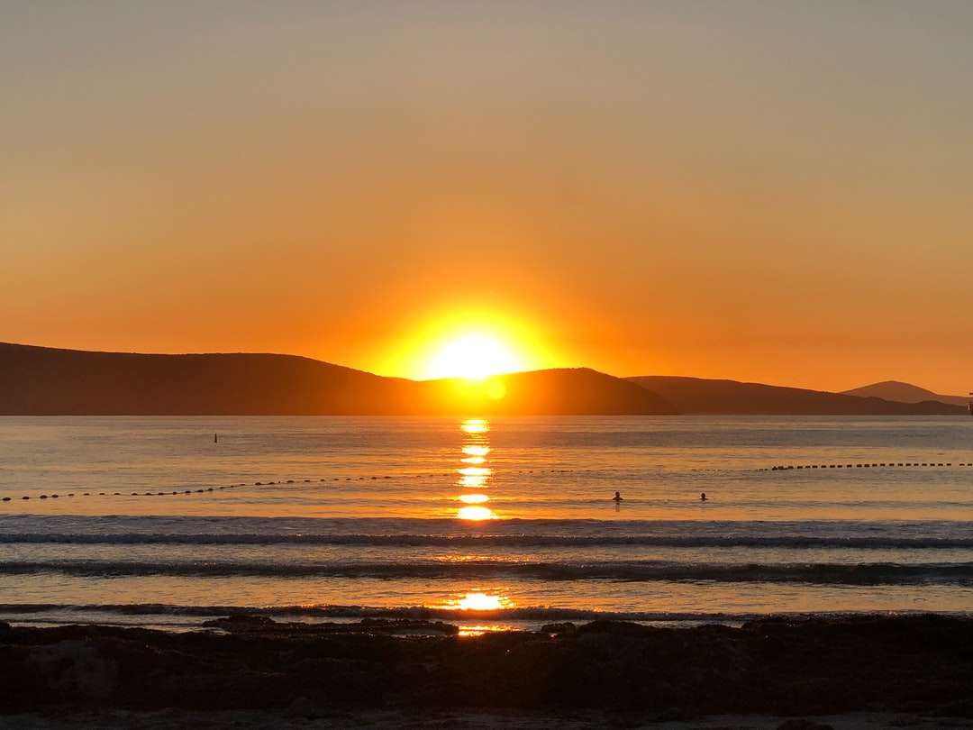 Silhuett av människor på stranden under solnedgången pussel på nätet