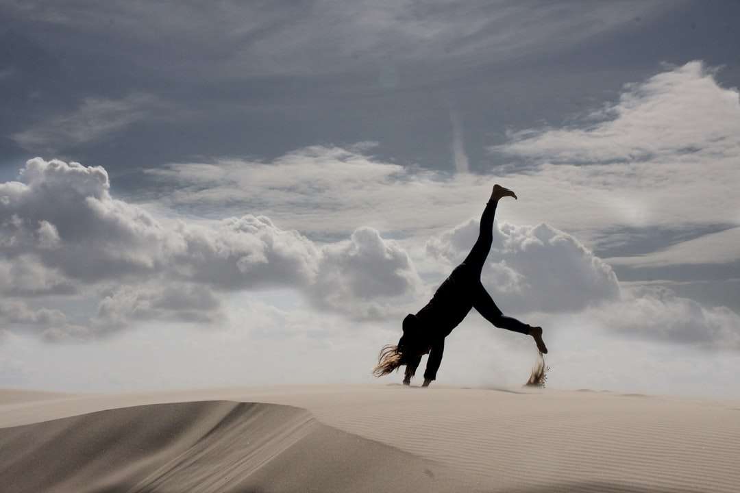 Kvinna i svart långärmad tröja och svarta byxor hoppar Pussel online