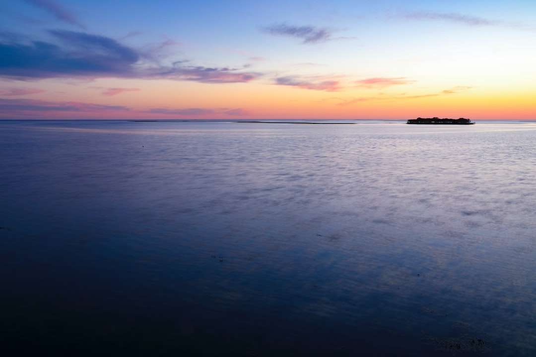 Cuerpo de agua bajo cielo azul durante la puesta de sol. rompecabezas en línea