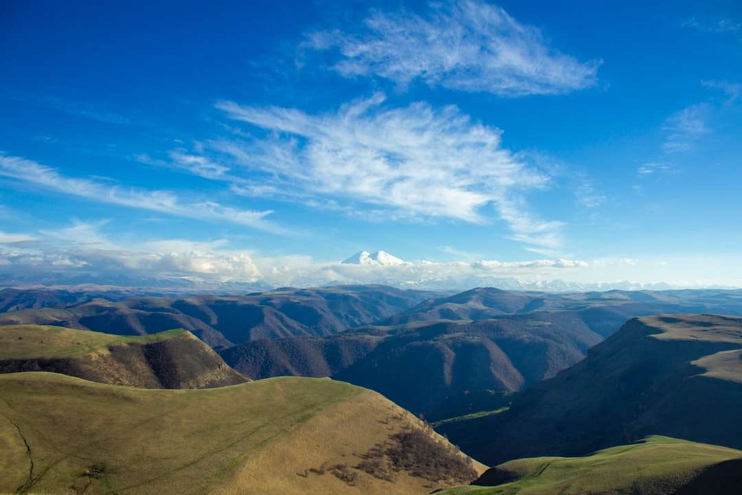 Munții maro și verde sub cerul albastru în timpul zilei jigsaw puzzle online