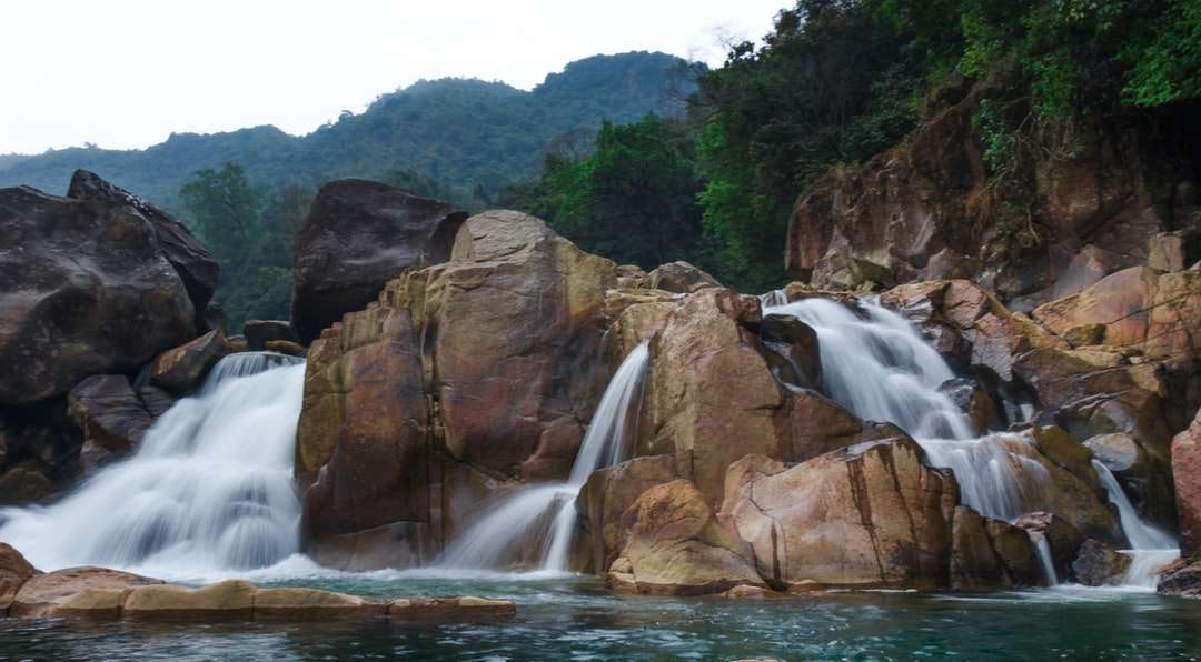 Wasserfälle zwischen dem braunen felsigen Berg tagsüber Online-Puzzle