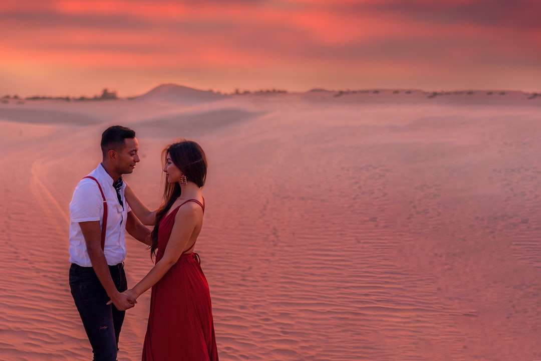 Uomo e donna in piedi sulla riva del mare durante il tramonto puzzle online
