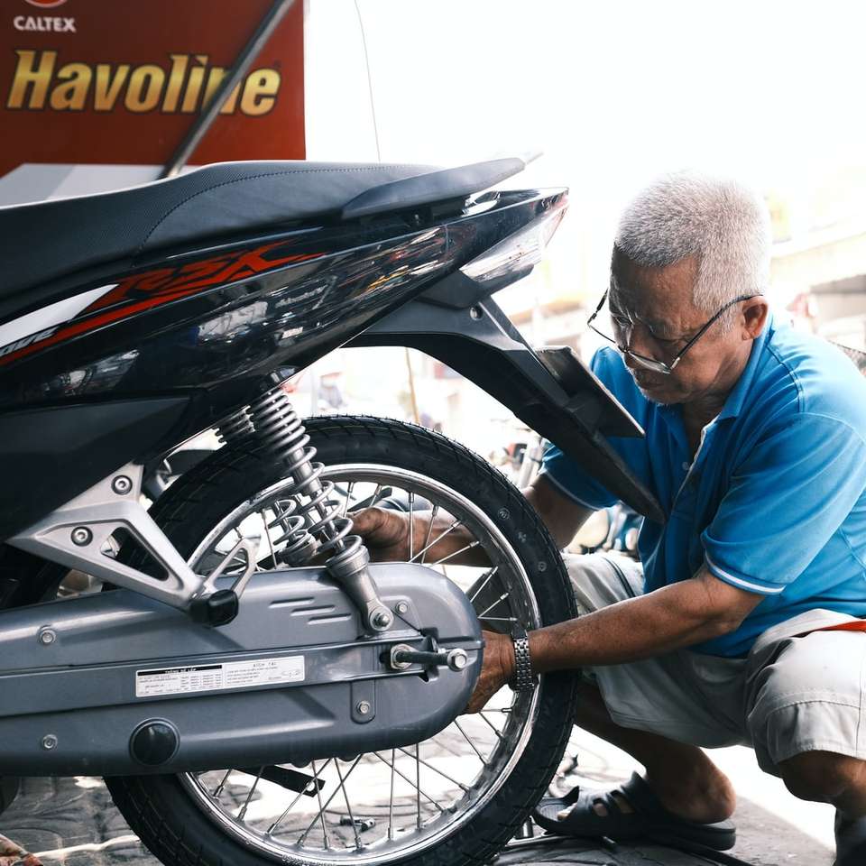 Muž v modré košile s dlouhým rukávem sedí na černém motocyklu online puzzle