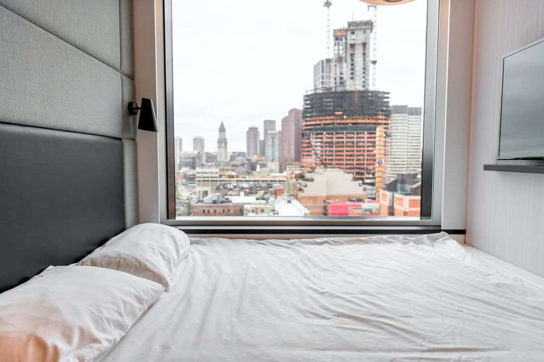 Weiße Bettwäsche in der Nähe von Fenster Puzzlespiel online