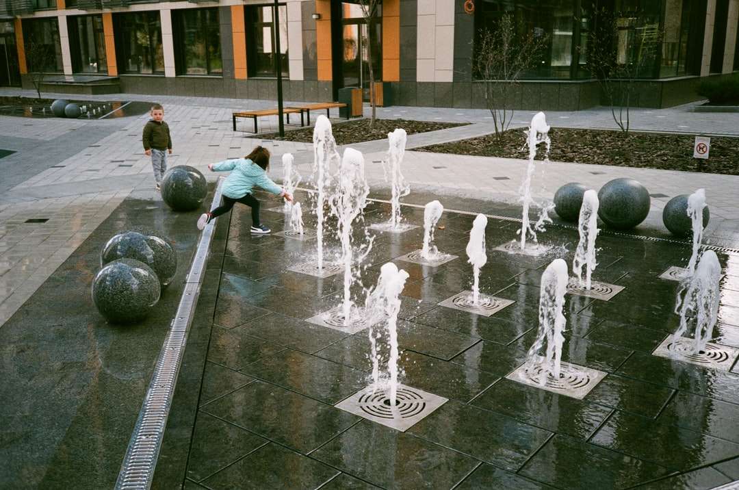 Människor som spelar på vatten fontän under dagtid Pussel online