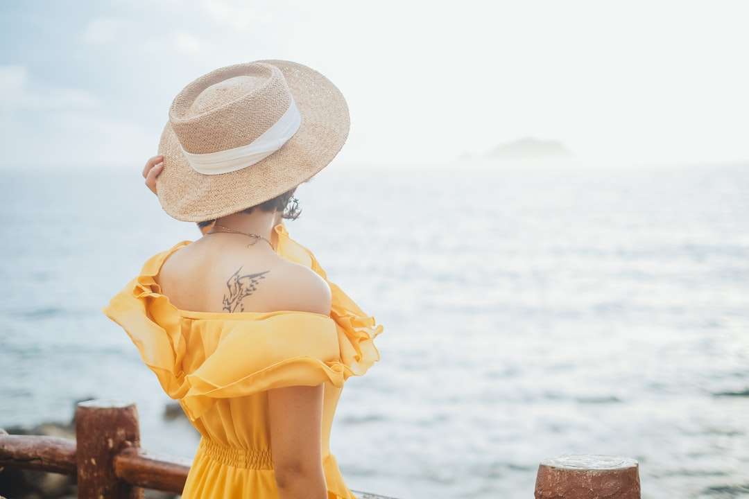 Nő sárga ruhában visel fehér nap kalapot kirakós online