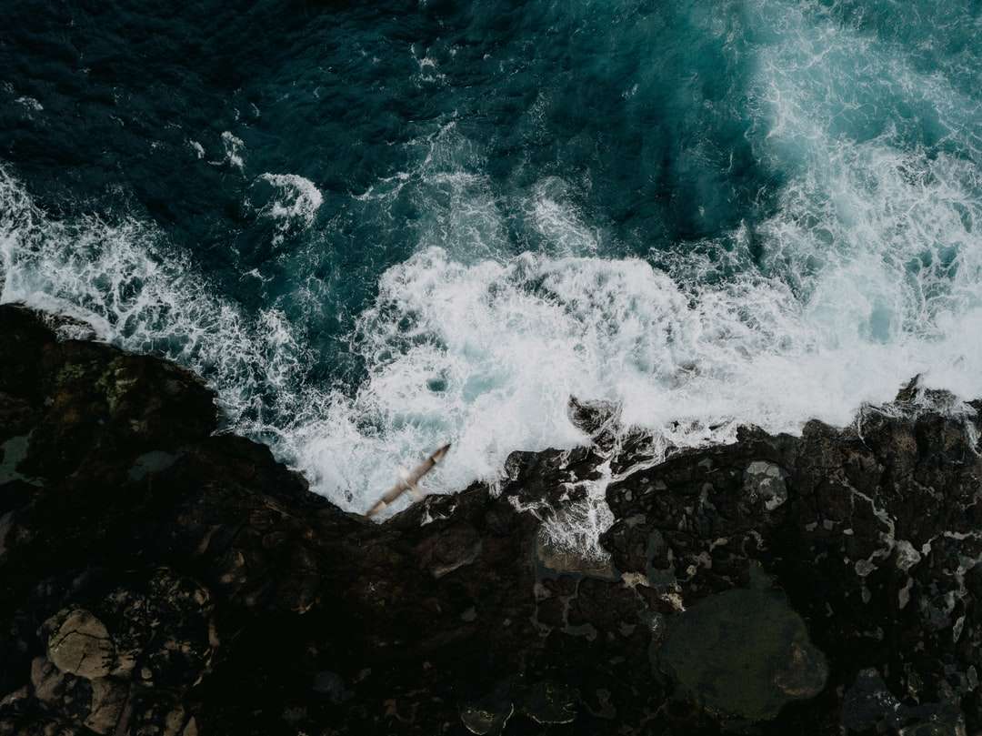 Ocean Waves kraschar på stenar under dagtid pussel på nätet