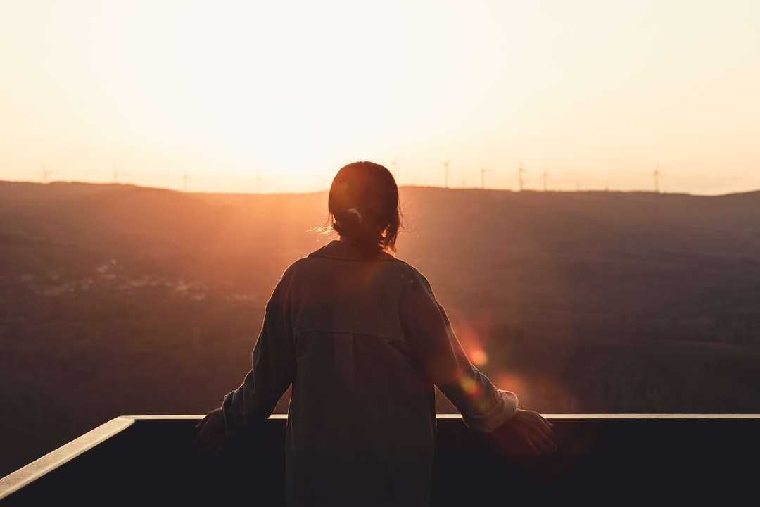 Silhouette dell'uomo in piedi sulla cima della costruzione durante il tramonto puzzle online