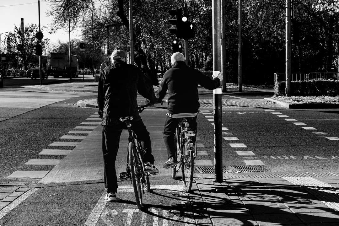 Grayscale fotografie de oameni de echitatie bicicleta pe drum jigsaw puzzle online