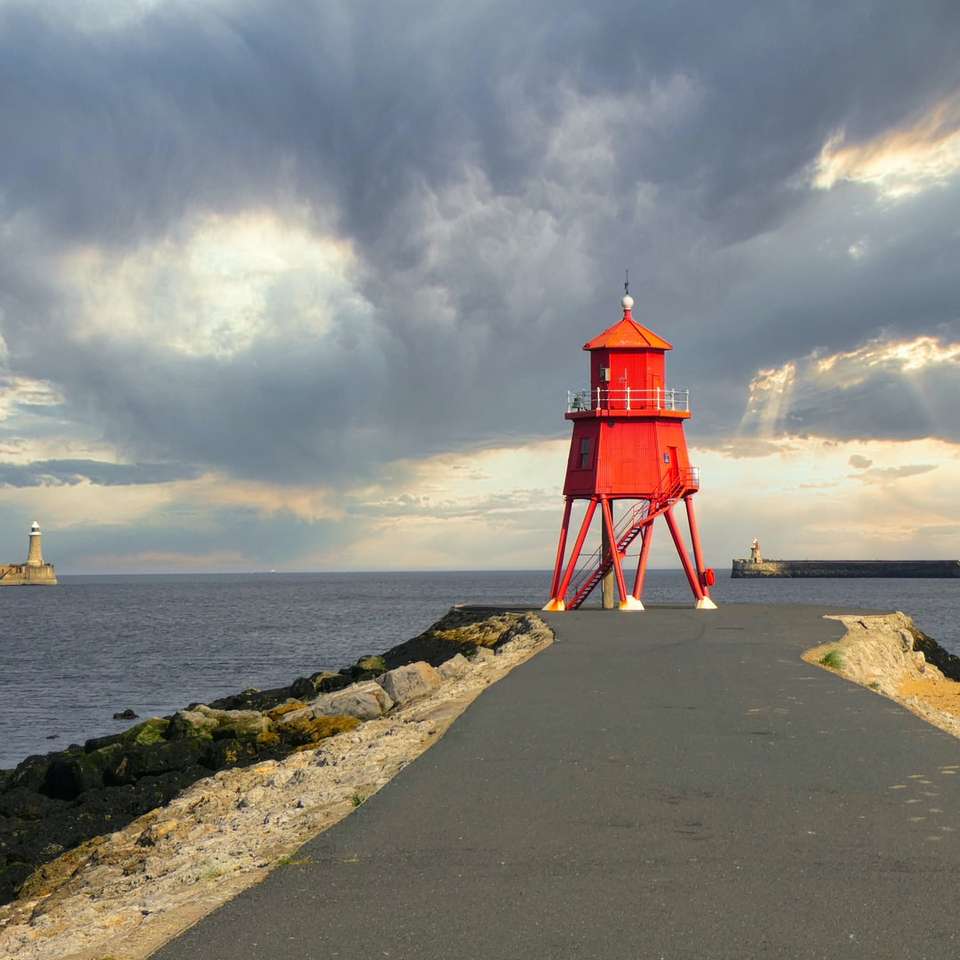 Roter und weißer Leuchtturm in der Nähe von Wasser des Wassers Online-Puzzle