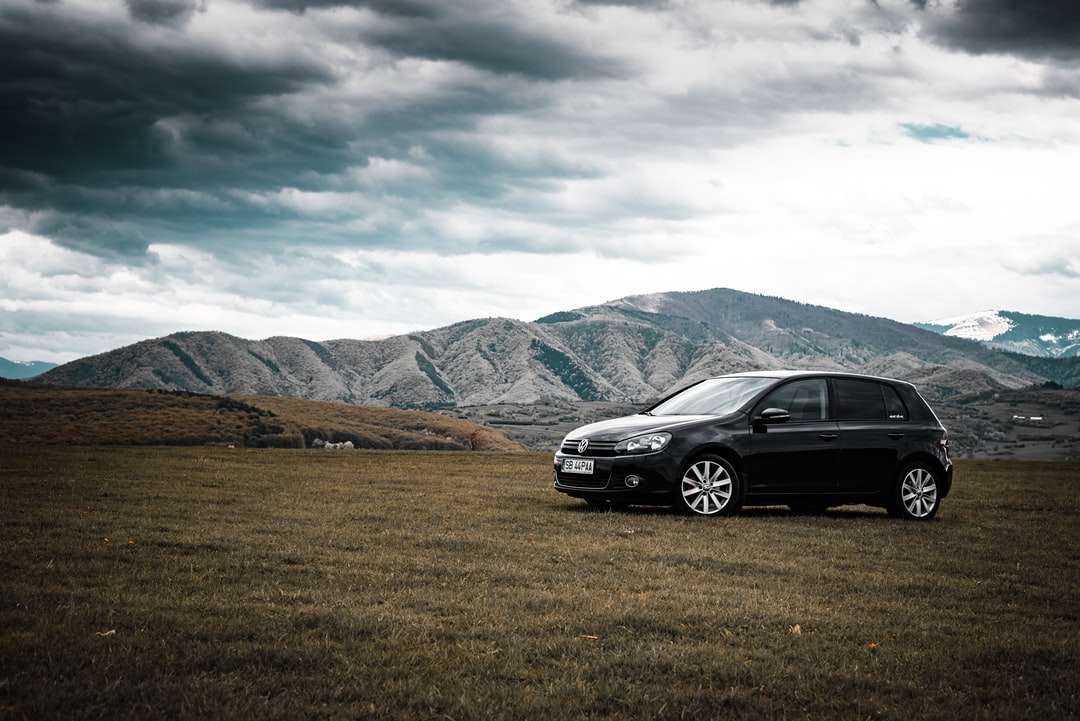 Μαύρο BMW M 3 σε πράσινο γρασίδι κοντά στα βουνά παζλ online