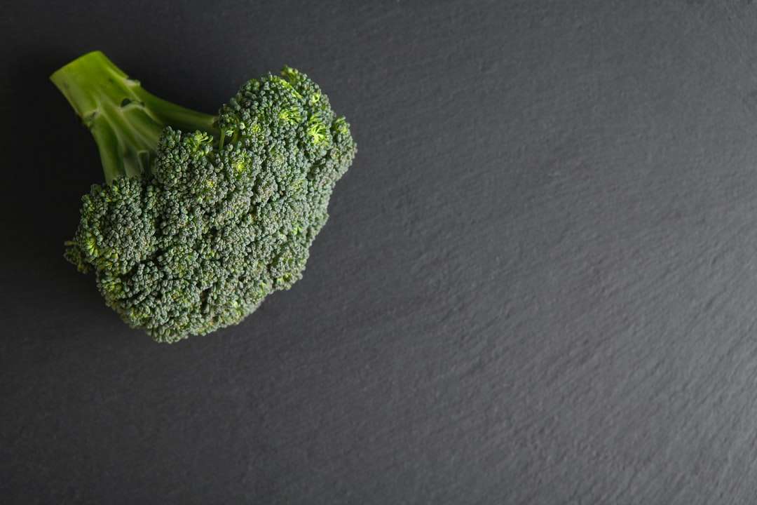 Grön broccoli på svart textil pussel på nätet