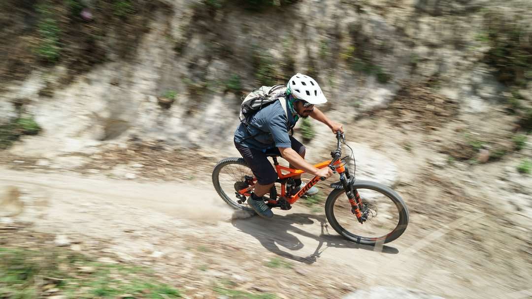 Ο άνθρωπος σε μπλε σακάκι ιππασία πορτοκαλί BMX ποδήλατο παζλ online