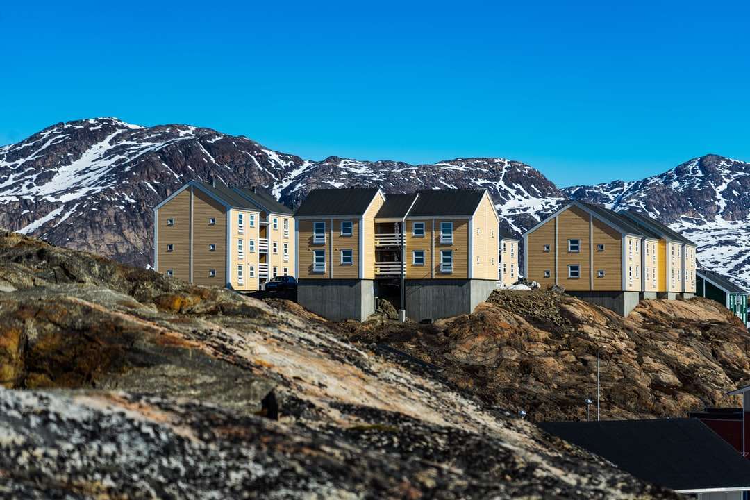 біло-коричнева бетонна будівля біля гори пазл онлайн