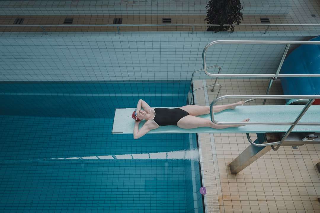 Mujer en pantalones cortos negros de pie junto a la piscina rompecabezas en línea