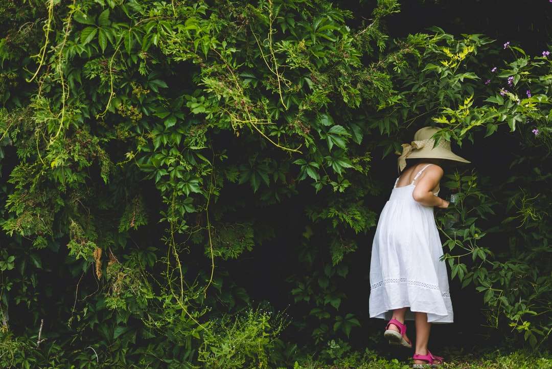 Vrouw in witte kleding die zich dichtbij groene bomen bevindt legpuzzel online