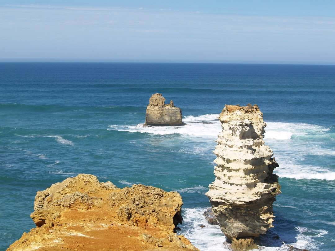 Formazione rocciosa marrone sul mare durante il giorno puzzle online