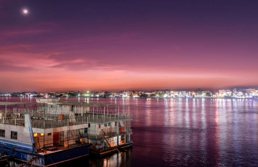 білий і коричневий човен на морі під час заходу сонця онлайн пазл