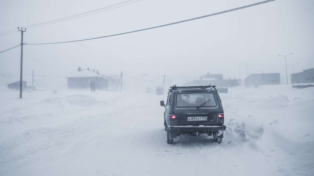 Zwarte SUV op sneeuw behandelde weg overdag online puzzel