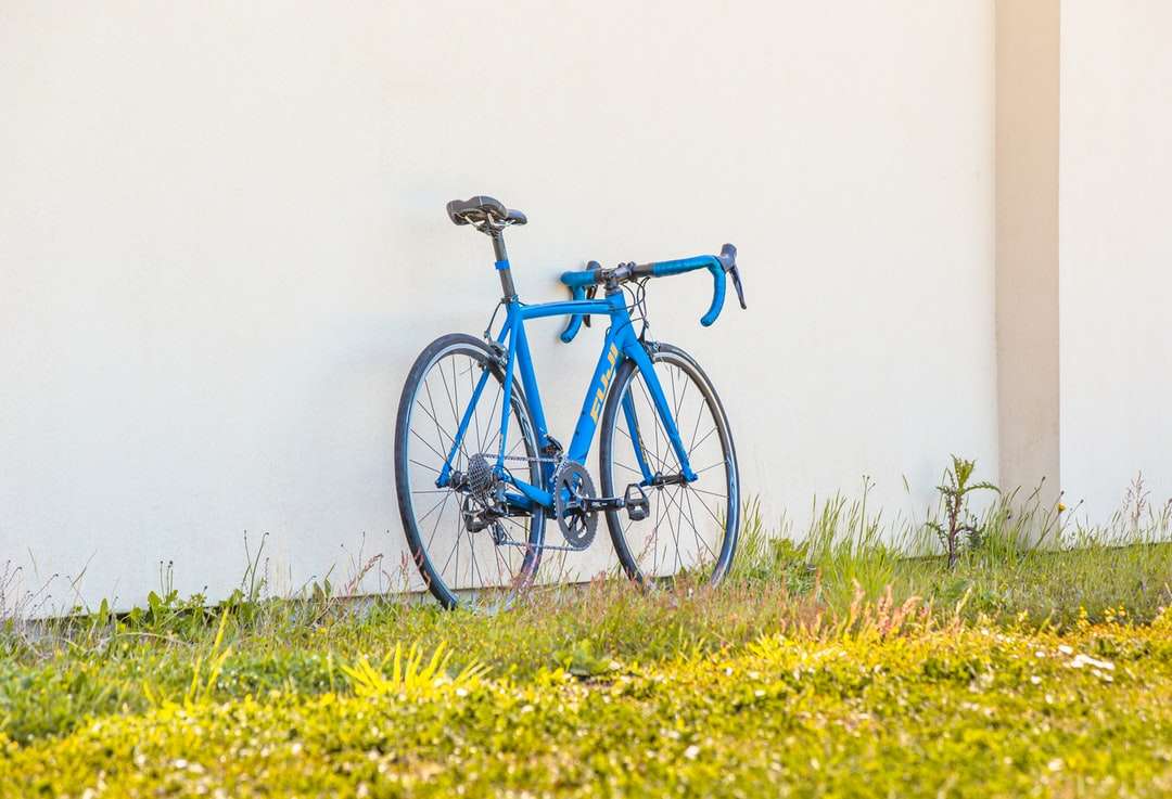 Vélo de route bleu et noir sur le champ de fleurs jaunes puzzle en ligne