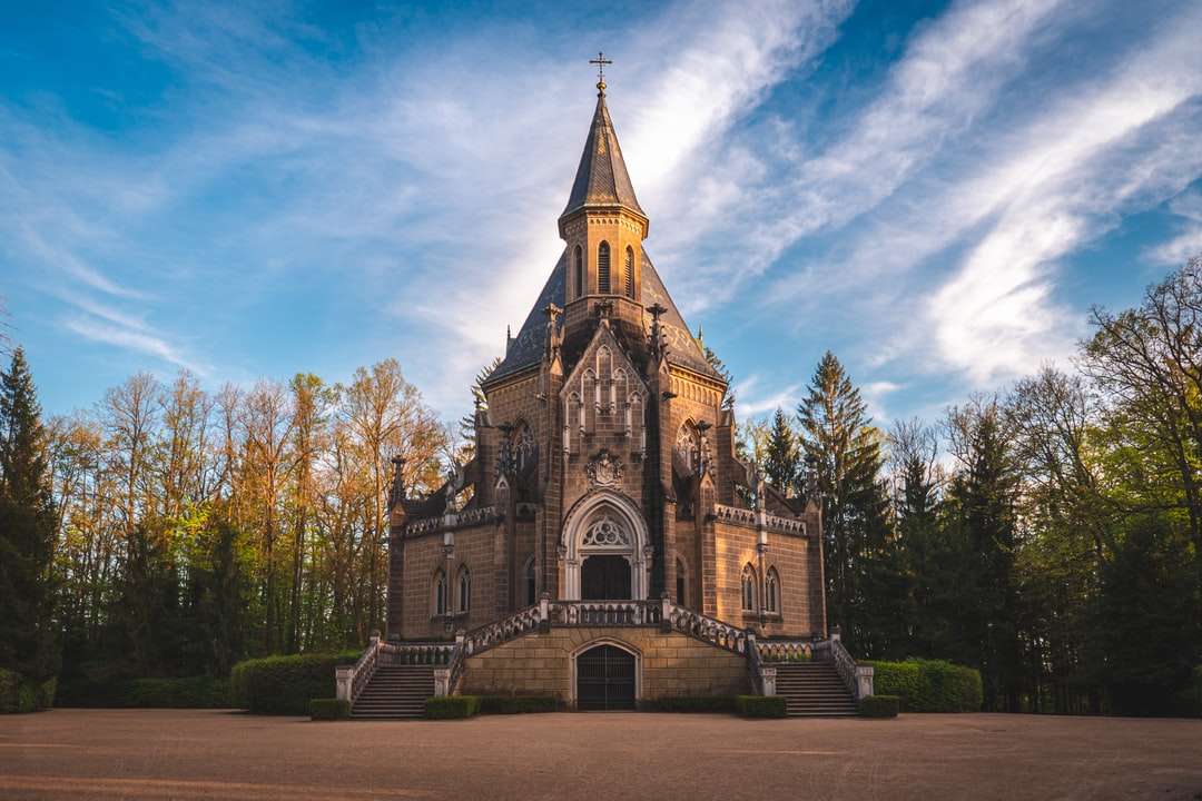 hnědý a šedý betonový kostel pod modrou oblohu během dne skládačky online