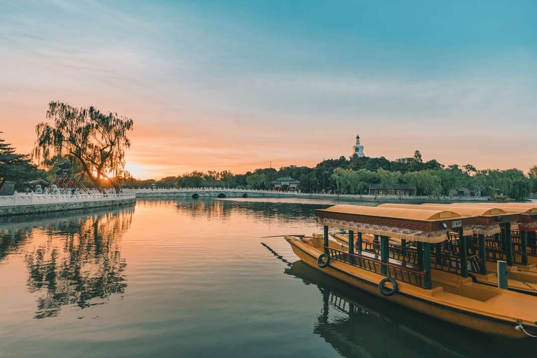 Braunes Boot am See während des Sonnenuntergangs Puzzlespiel online