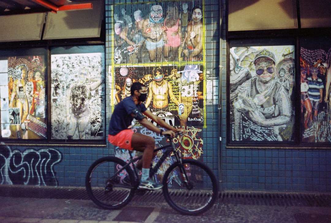 Човек в синия наклон на екипажа тениска езда на черен велосипед онлайн пъзел