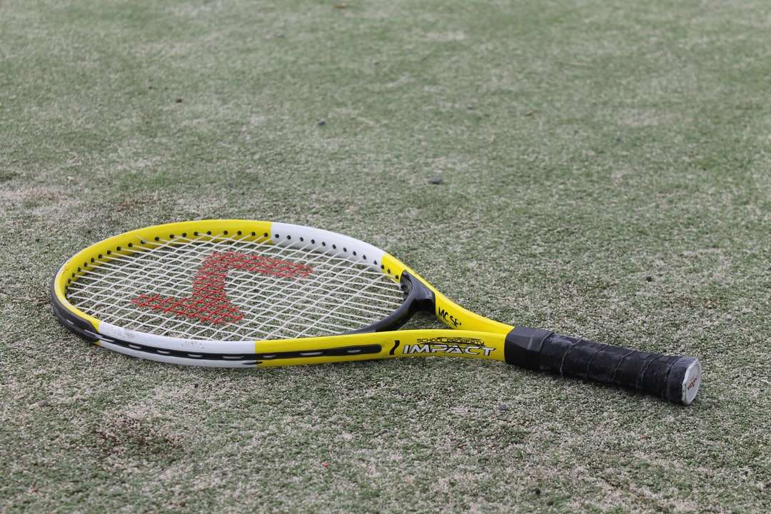 žlutá a černá tenisová raketa na zelené louce skládačky online