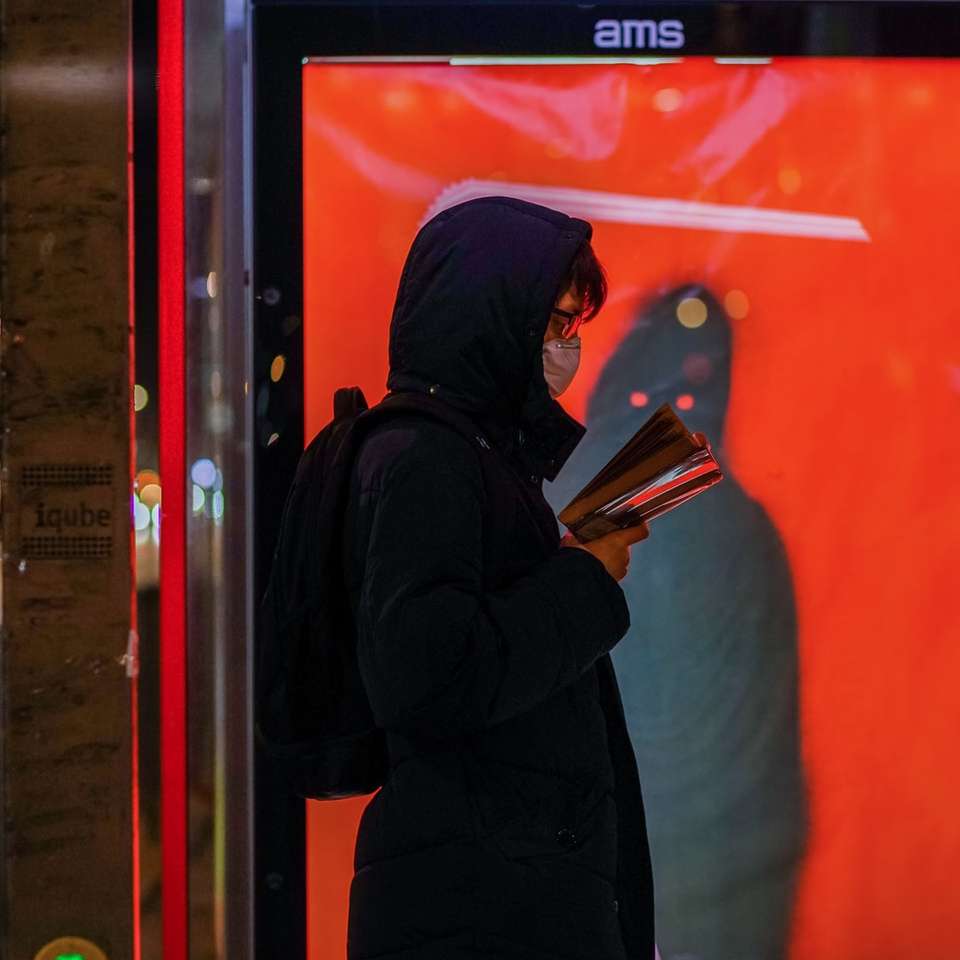 piros fal mellett álló fekete kapucnis nő kirakós online