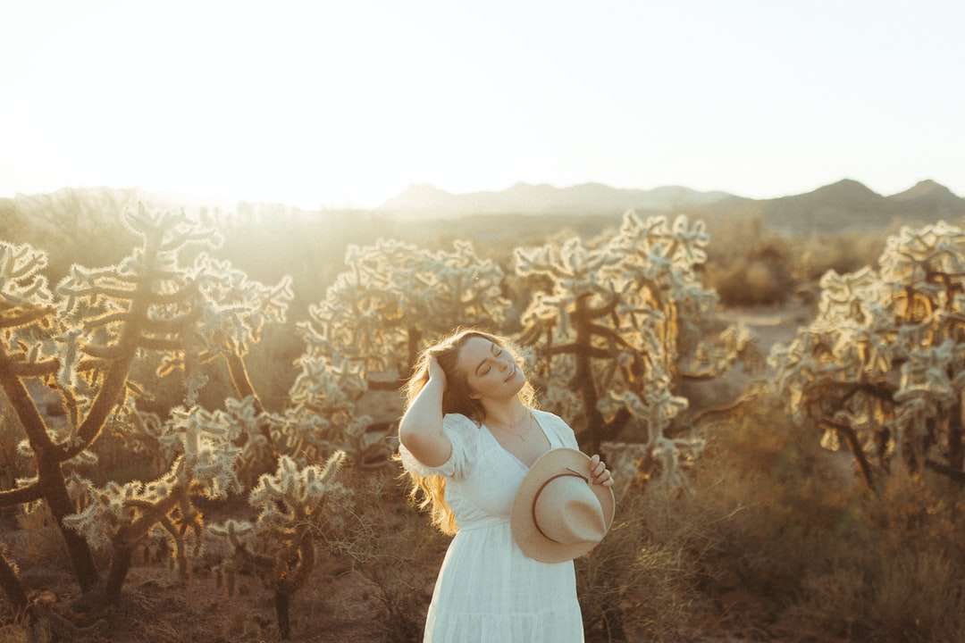 kvinna i vit klänning som står på brunt blommafält pussel på nätet