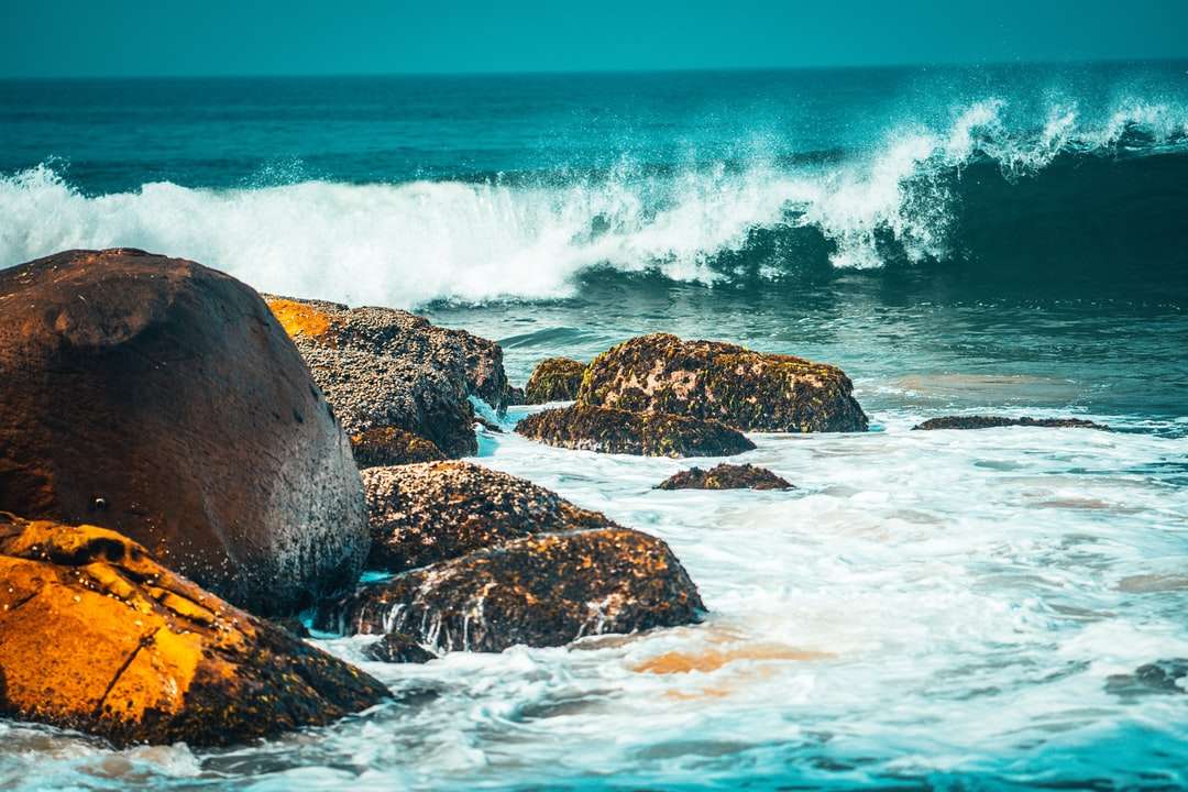 Formação de rocha marrom no mar durante o dia puzzle online