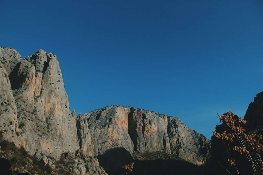 Formación de roca marrón bajo el cielo azul durante el día rompecabezas en línea