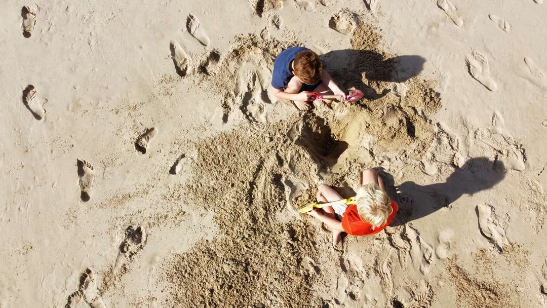 昼間に砂の上に横たわっている2人の男の子 ジグソーパズルオンライン