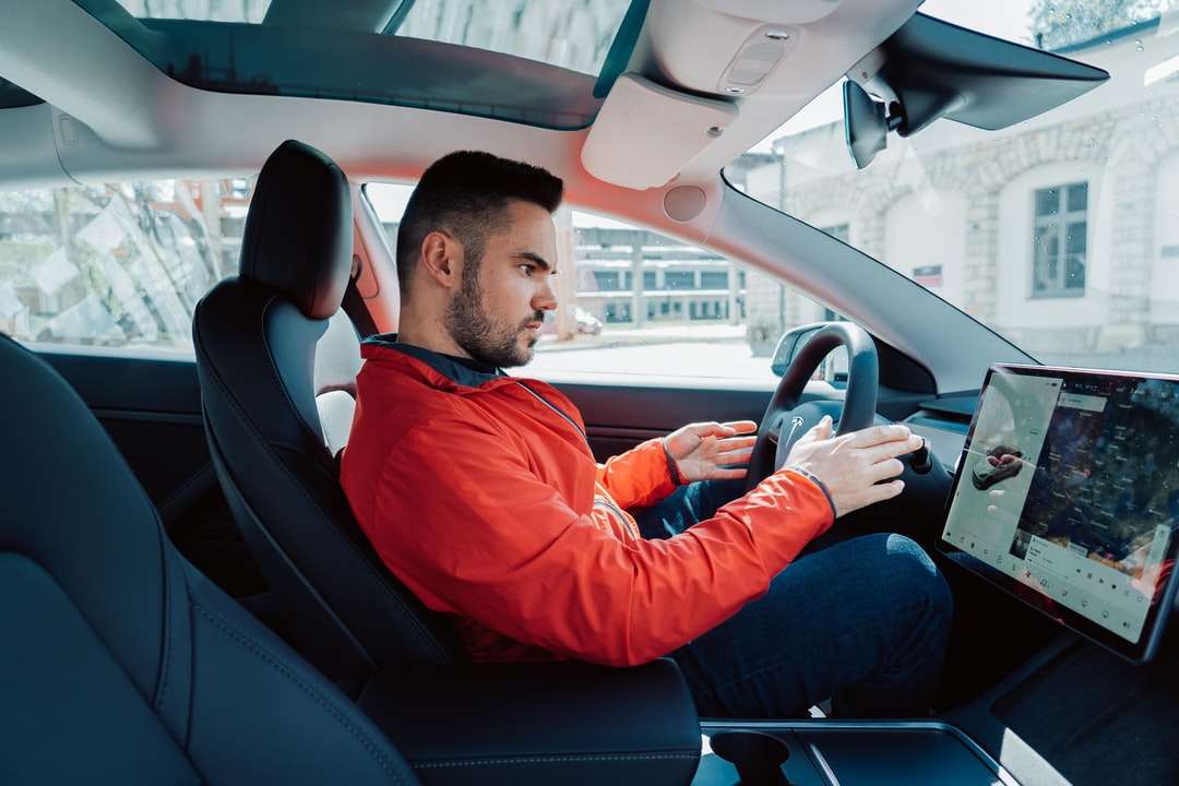 hombre con camisa roja de manga larga conduciendo un coche rompecabezas en línea