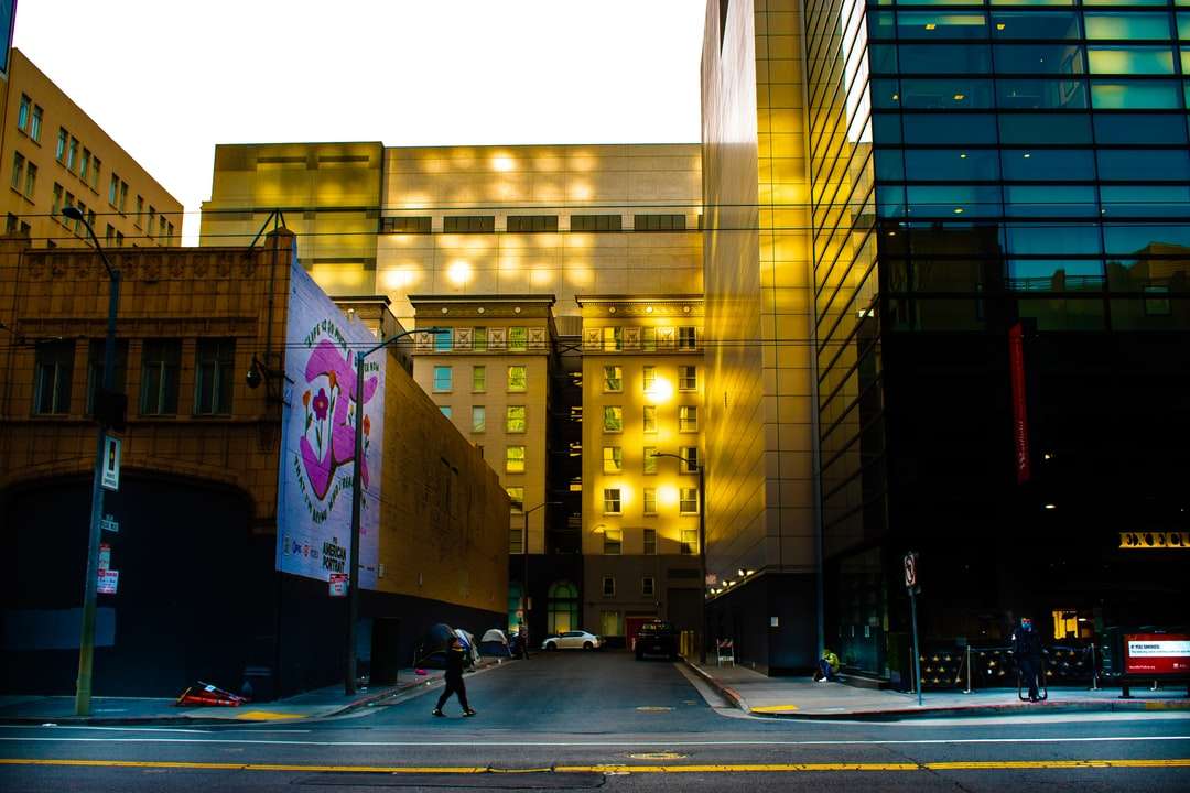 Хората ходене по пешеходна платна близо до високата сграда онлайн пъзел