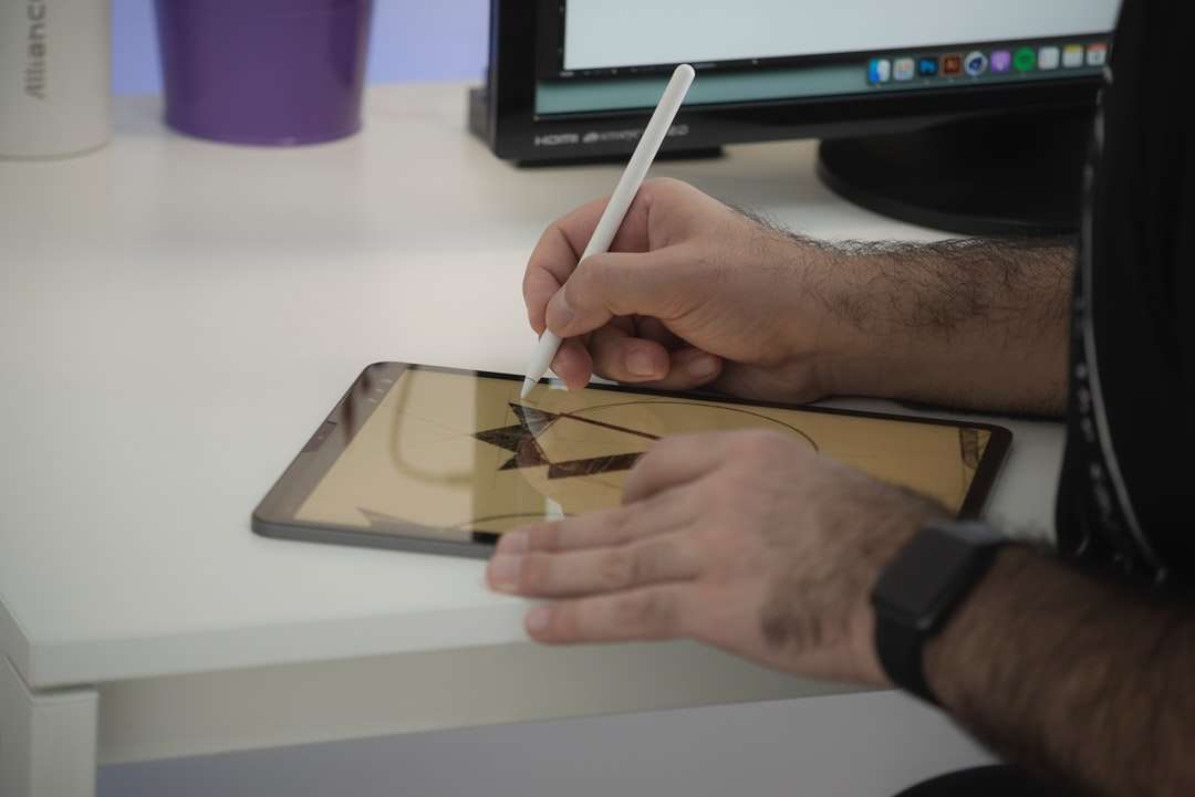 човек, който държи бяла писалка, пише върху бяла хартия онлайн пъзел