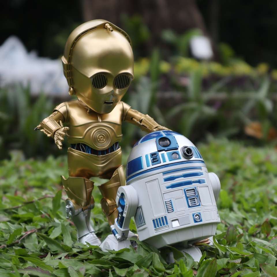vit och blå robot leksak på grönt gräs under dagtid Pussel online