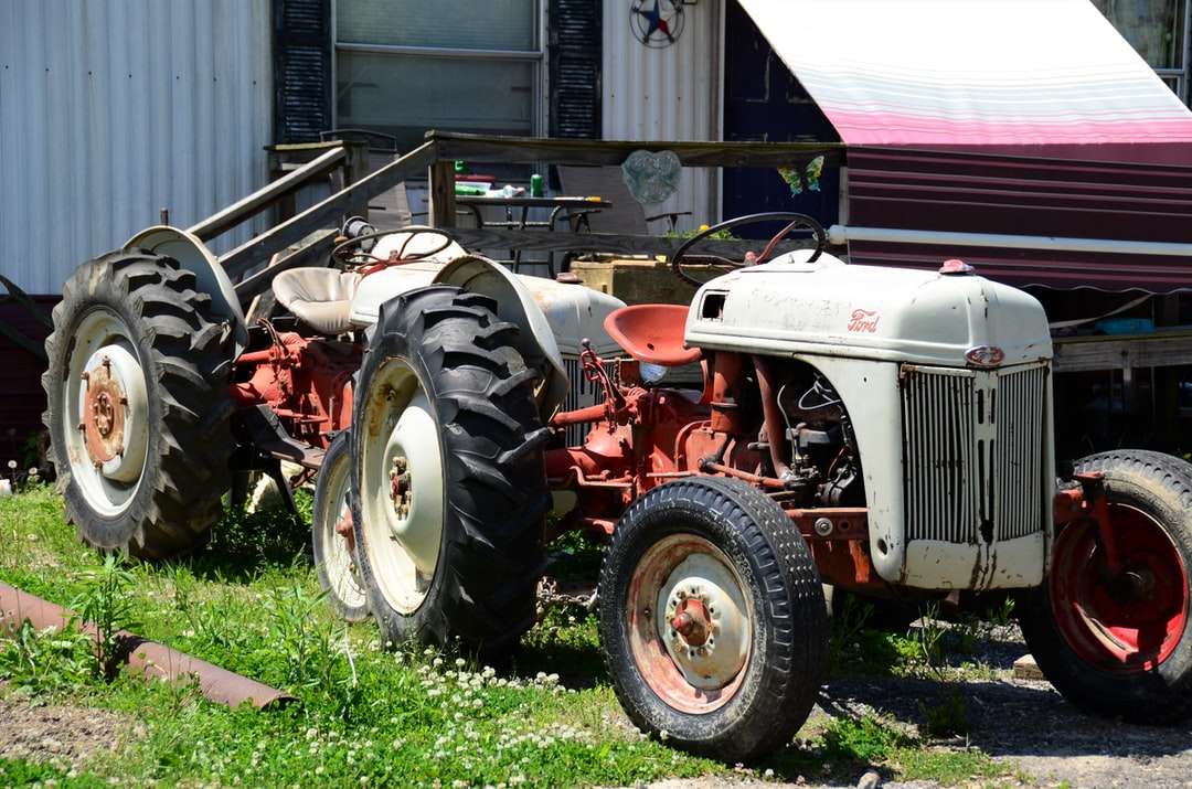 Червен и сив трактор на зелено трева онлайн пъзел
