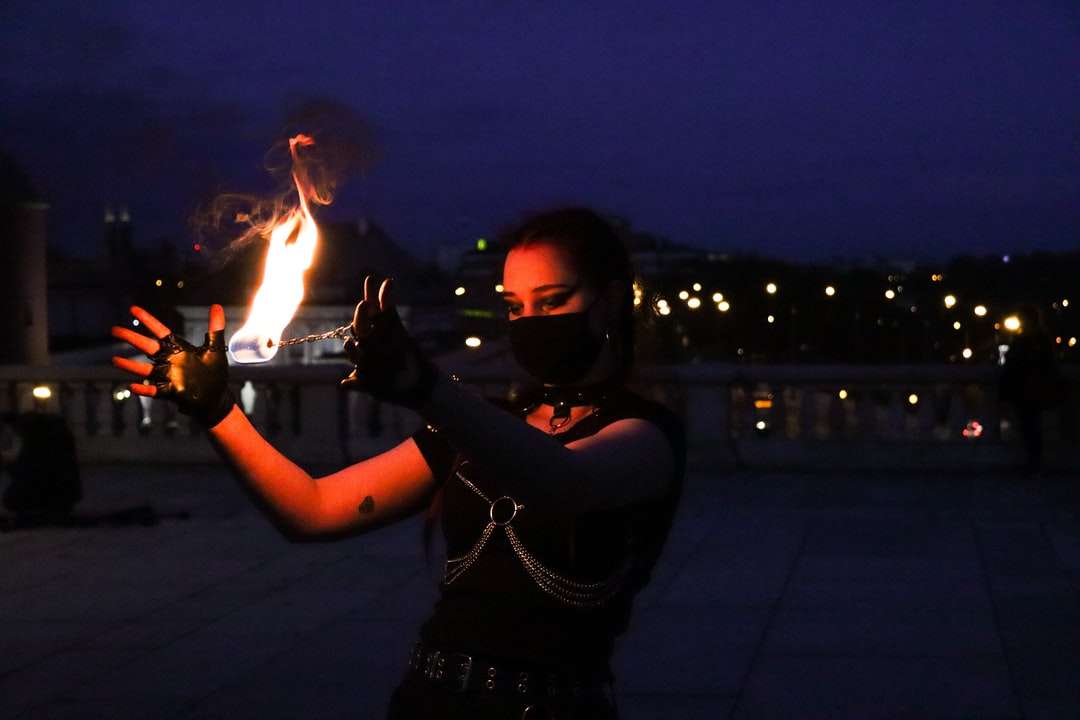 женщина в черной рубашке с длинным рукавом держит огонь онлайн-пазл