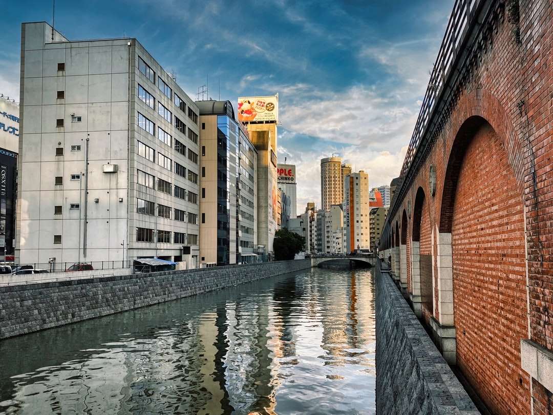 clădire din beton alb lângă râu sub cerul albastru puzzle online
