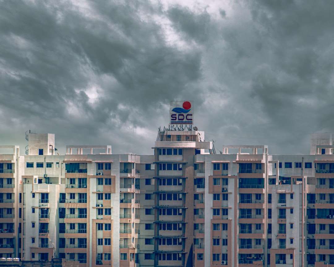 біло-блакитна бетонна будівля під сірими хмарами пазл онлайн