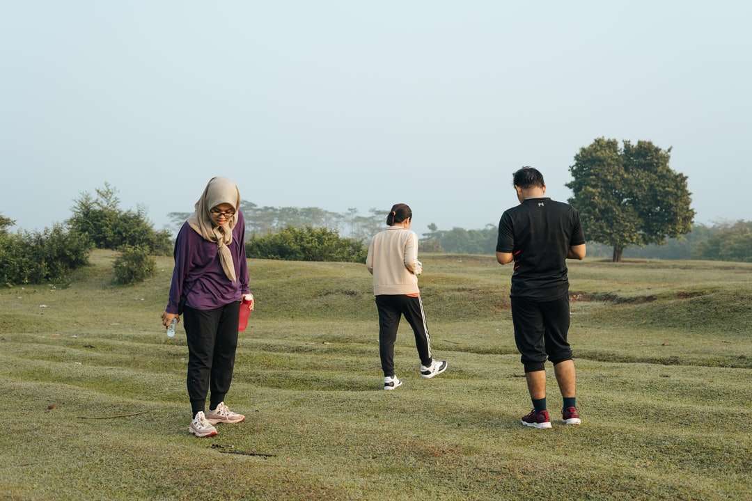 3 homens e 2 mulheres em pé no campo de grama verde puzzle online