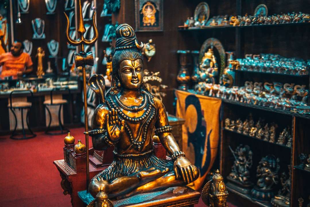 Gouden Boeddhabeeldje op bruine houten tafel online puzzel