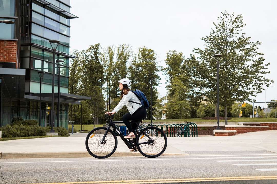 Човек в бяла риза езда на велосипеда по пътя през деня онлайн пъзел