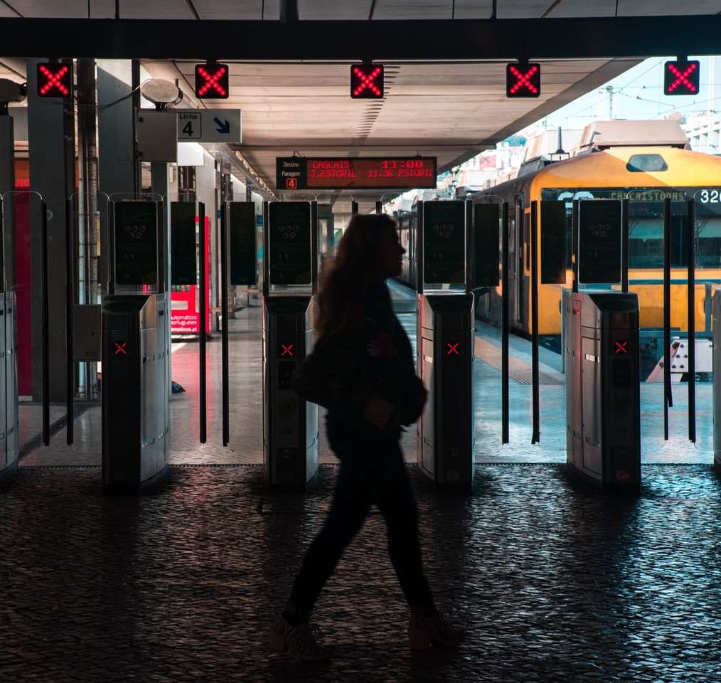 Silhouette einer Frau, die auf dem Bahnhof spazieren geht Online-Puzzle
