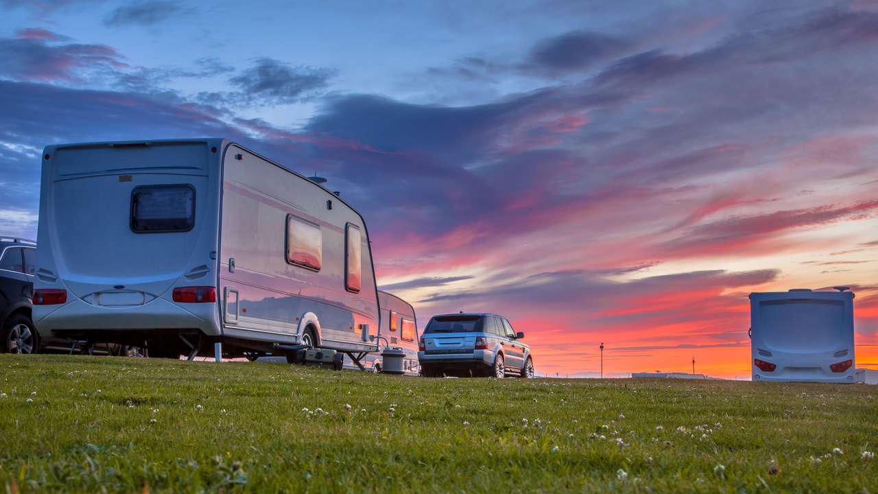 Caravans and cars parked on a grassy campground online puzzle