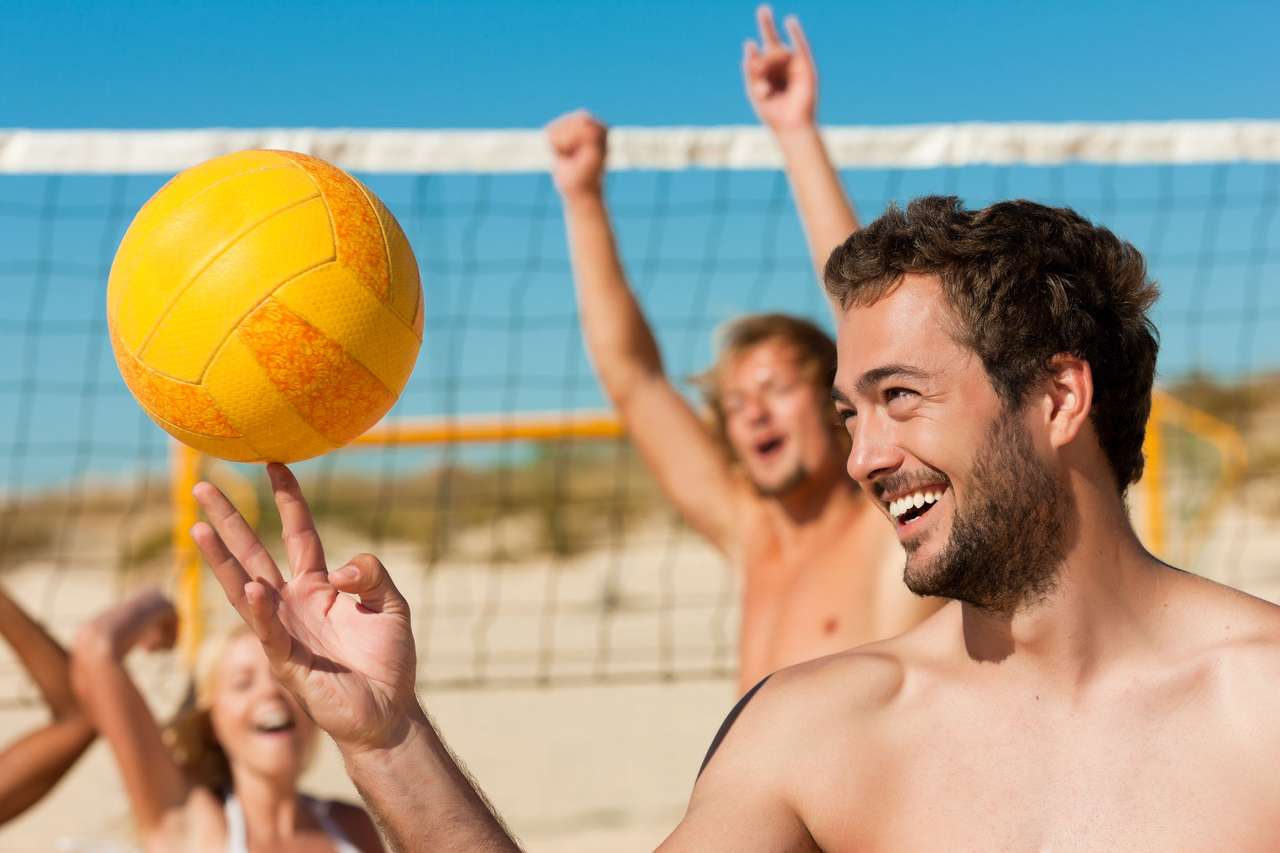 Vänner som spelar beachvolleyboll pussel på nätet