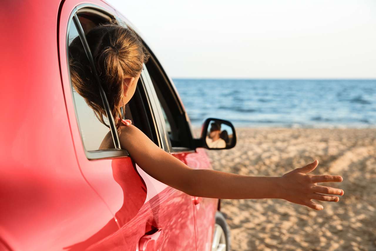 Μικρό κορίτσι που κλίνει έξω από το παράθυρο του αυτοκινήτου online παζλ